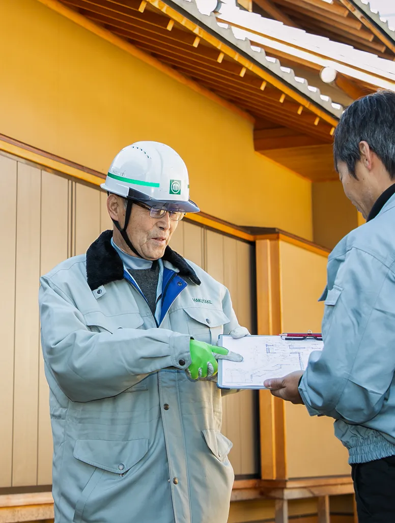 図面を指差しながら現場で作業内容の確認や指示を行うS・Sさん